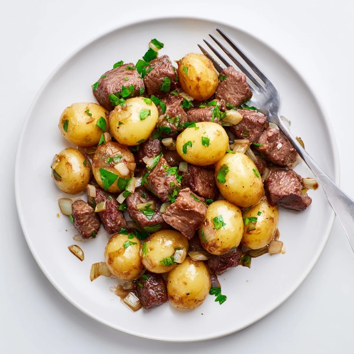 Savory slow cooker garlic butter steak bites served with tender potatoes and herbs