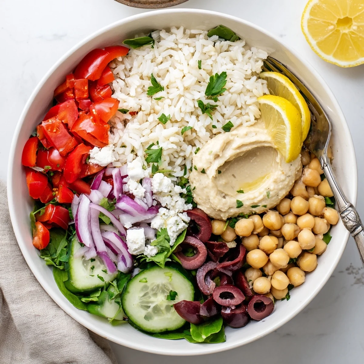 Healthy Mediterranean rice bowl drizzled with lemon-tahini dressing and garnished with fresh parsley and olives