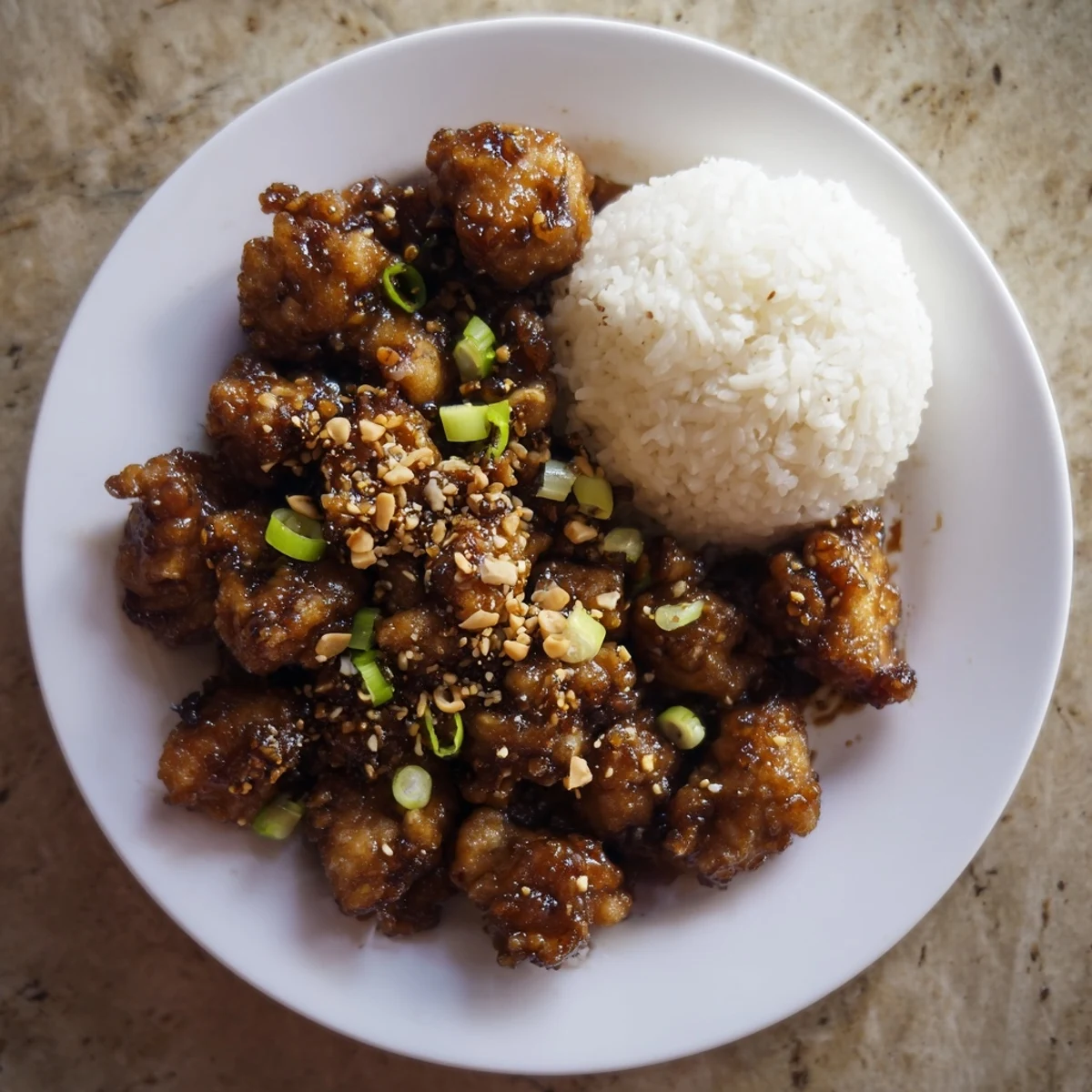 Garnished Mongolian chicken featuring green onions and red chili flakes on a serving platter