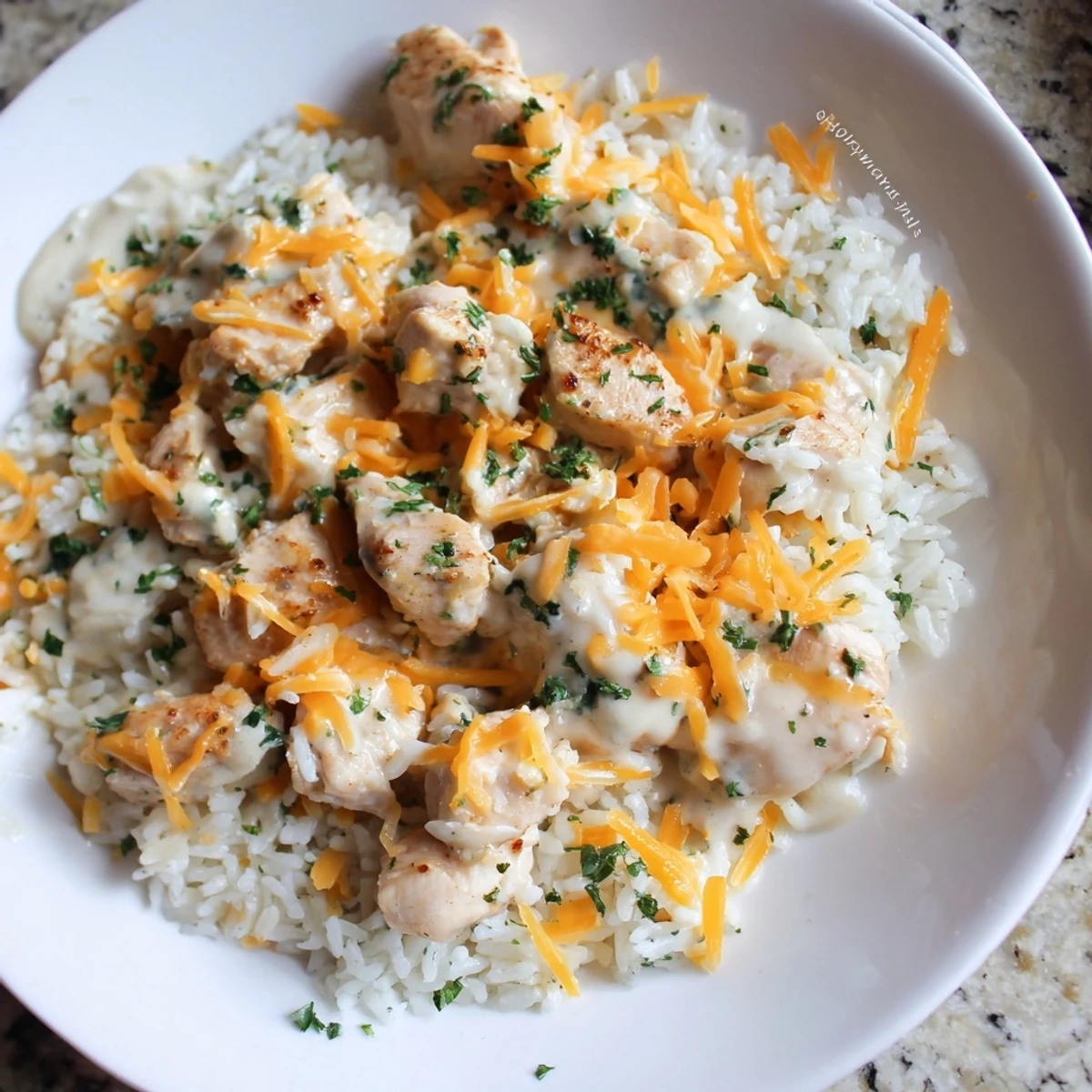 Golden brown chicken breasts nestled in creamy rice with melted cheddar cheese topping