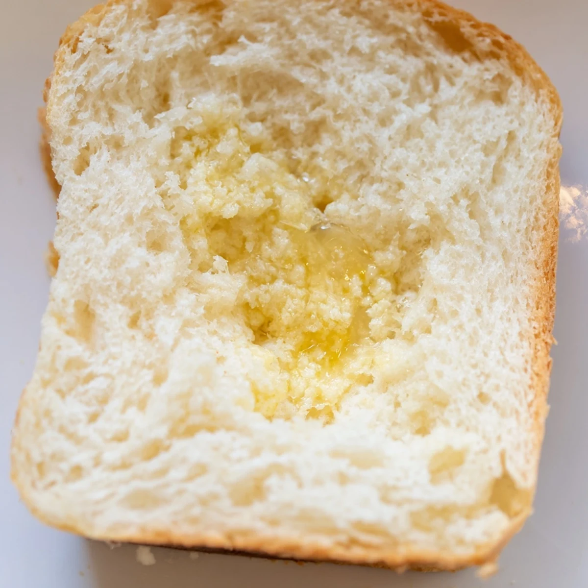 Golden zero carb yogurt bread loaf sliced on wooden board with sesame topping