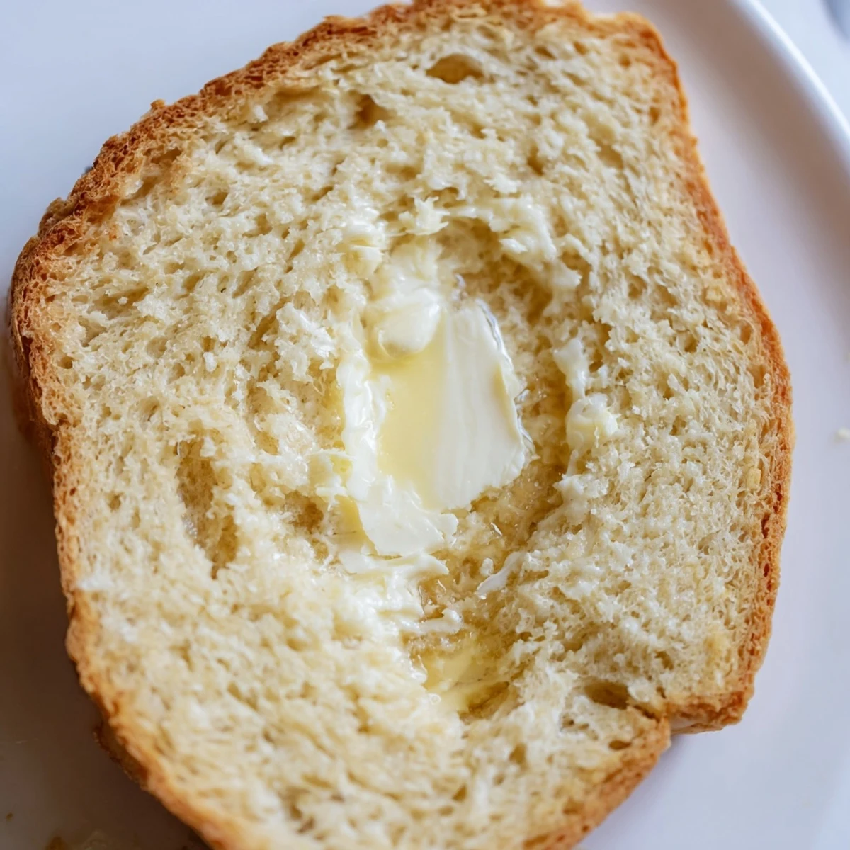 Fluffy zero carb yogurt bread toasted with melted butter on white plate