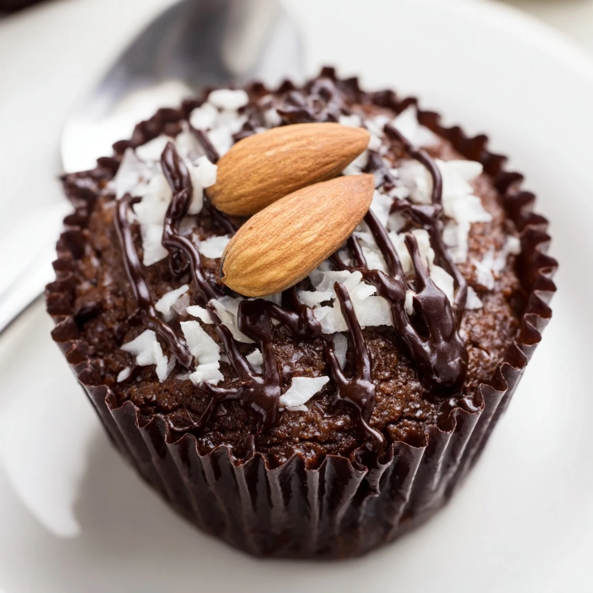 Rich flourless almond joy cupcakes drizzled with melted chocolate and topped with roasted almonds
