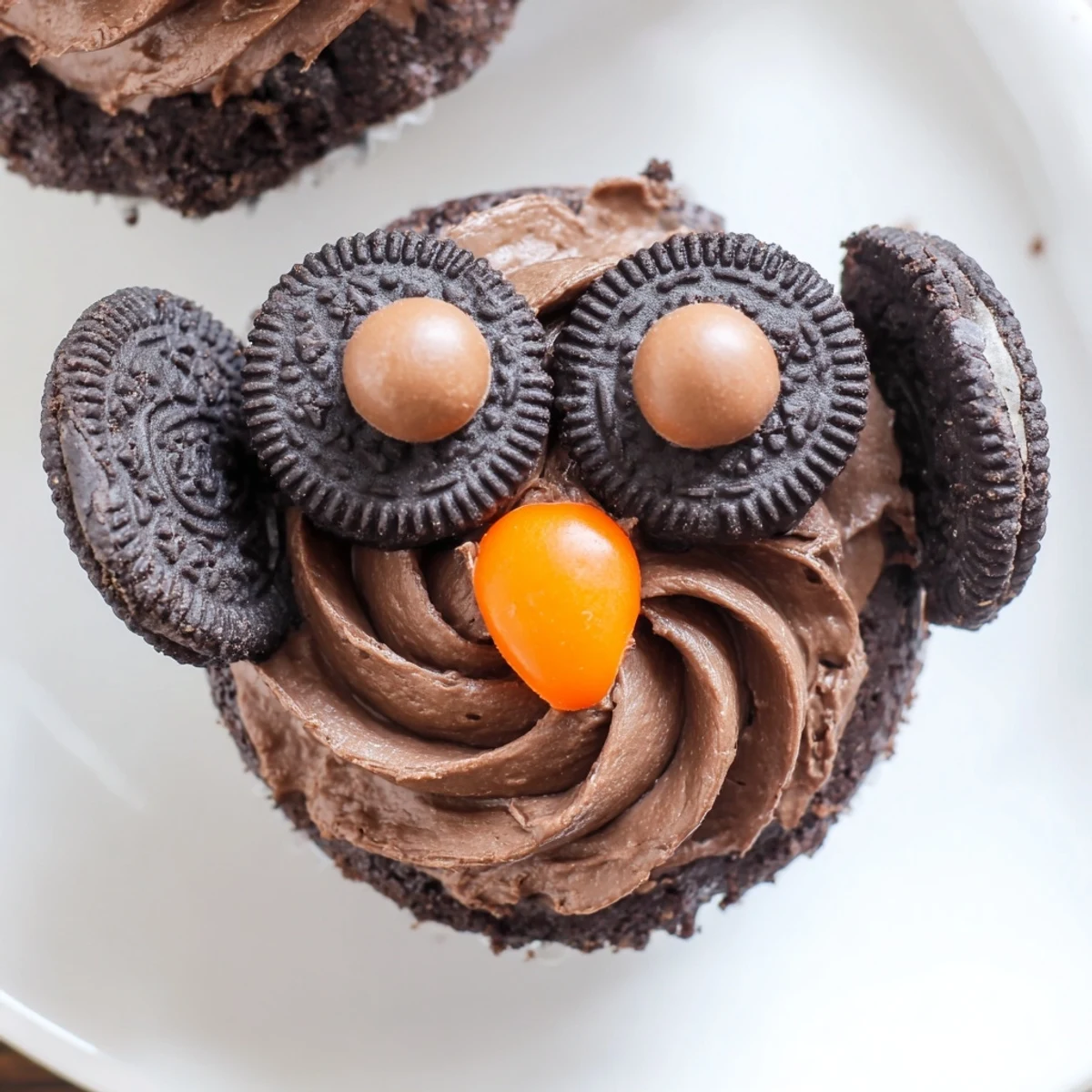 Adorable Oreo Owl Cupcakes featuring cookie eyes and bright orange candy beaks