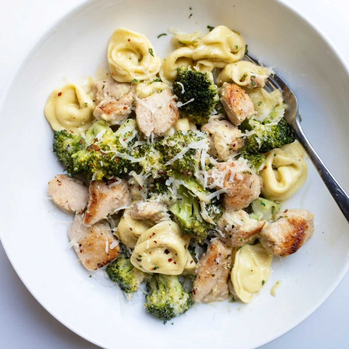 Creamy Garlic Parmesan Tortellini Chicken Broccoli Recipe steaming, saucy pasta with golden chicken