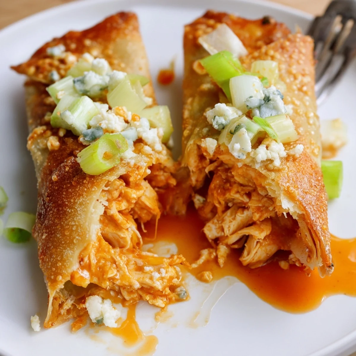Crispy golden Buffalo Chicken Egg Rolls piled with melty cheese, served with ranch.