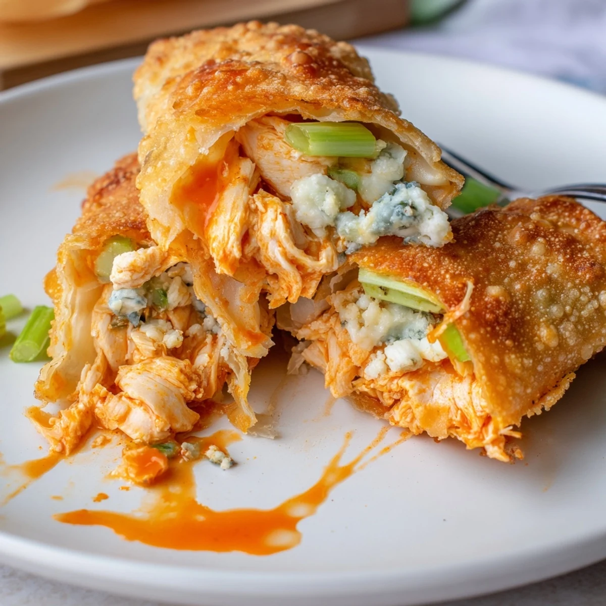 Steaming Buffalo Chicken Egg Rolls revealing spicy shredded chicken and crunchy celery.