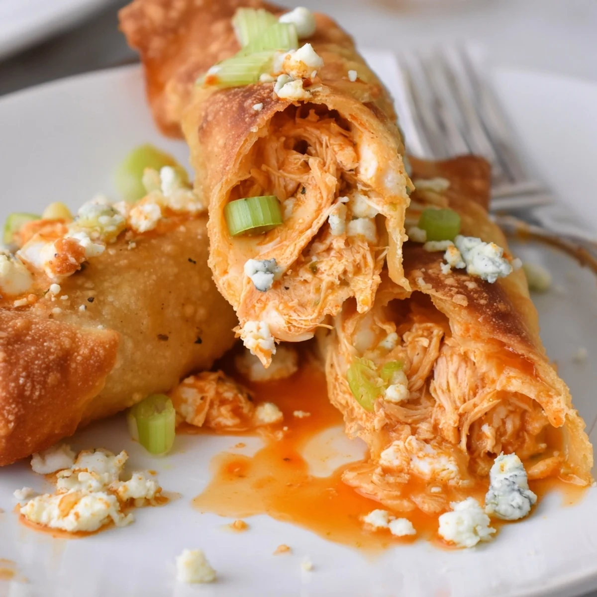 Game-day platter of Buffalo Chicken Egg Rolls with blue cheese dip and napkins.