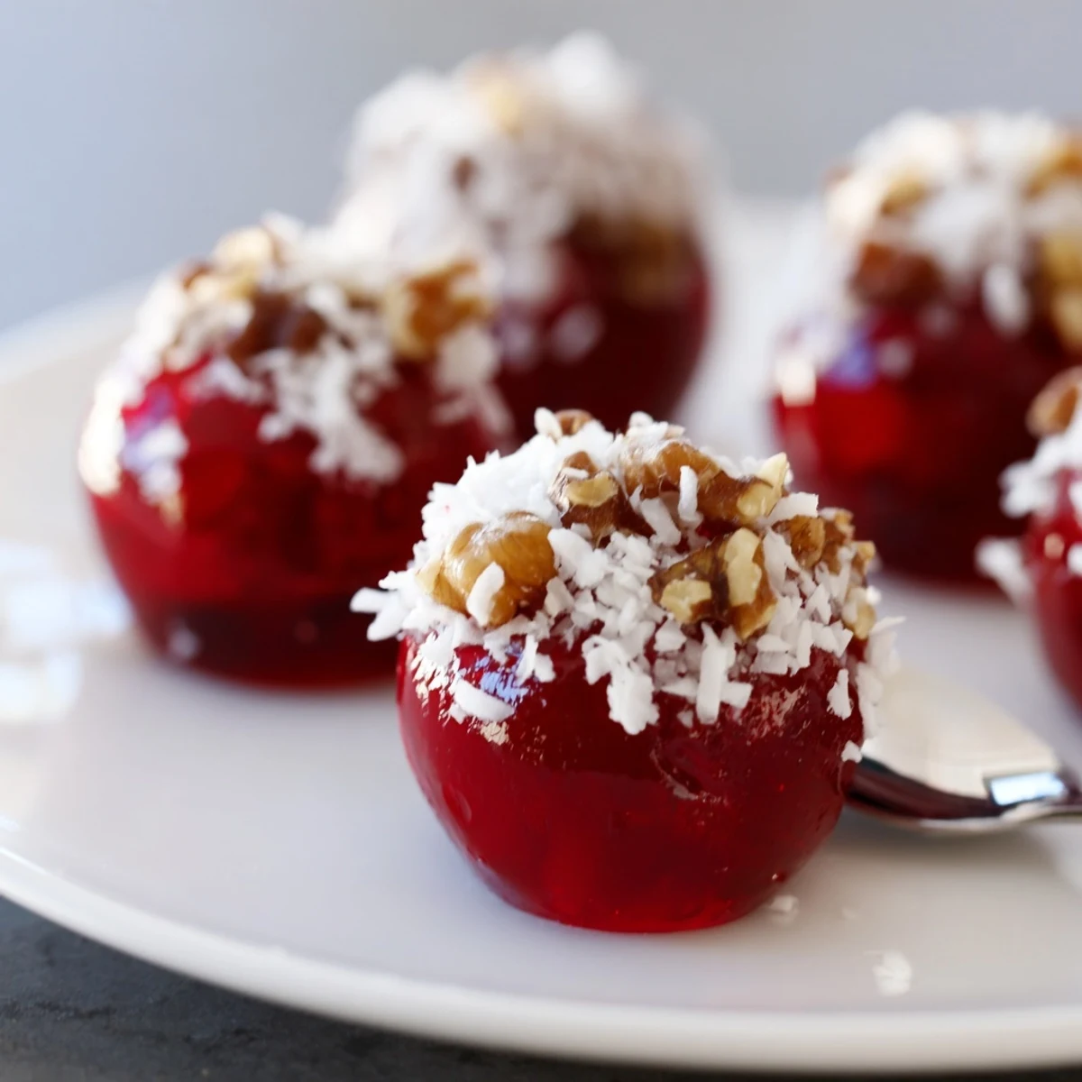 Christmas Jello Balls glistening with coconut, berry-sweet centers, holiday party tray