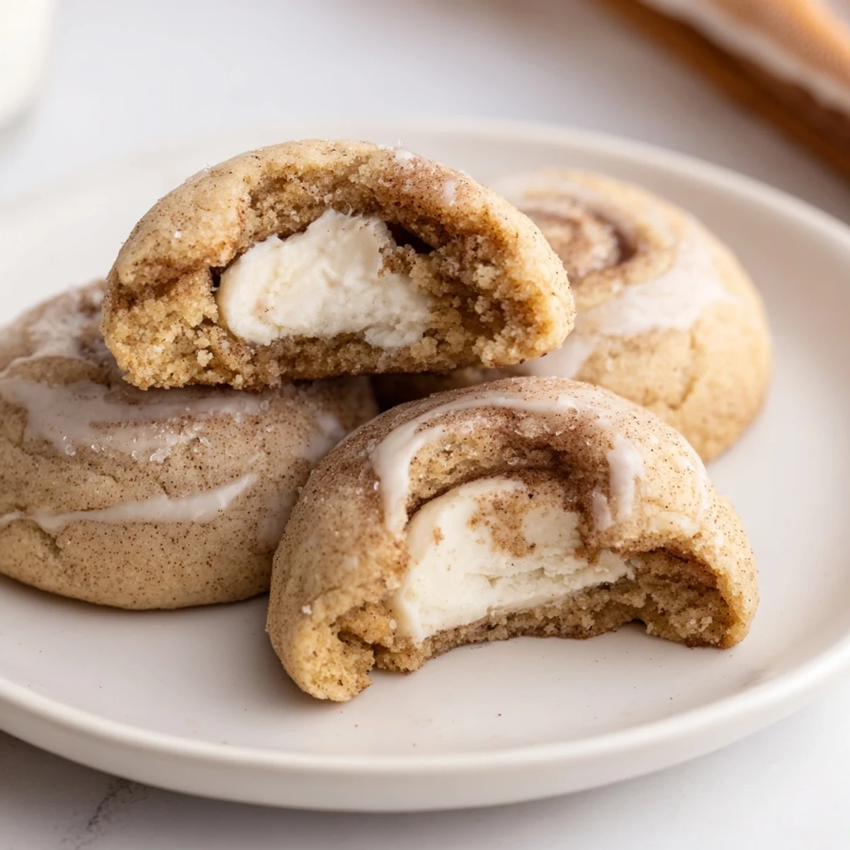 Warm Cinnamon Roll Cheesecake Cookies on a wire rack, gooey cream cheese  