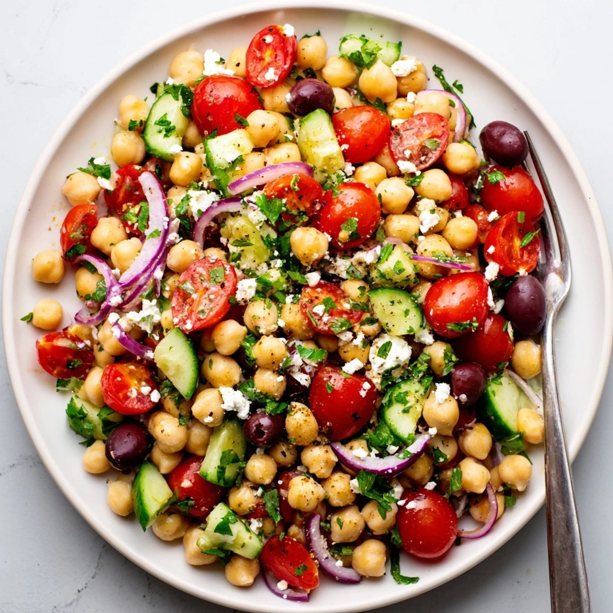 Fresh chickpea salad with diced cucumbers tomatoes red peppers and tangy lemon herb dressing