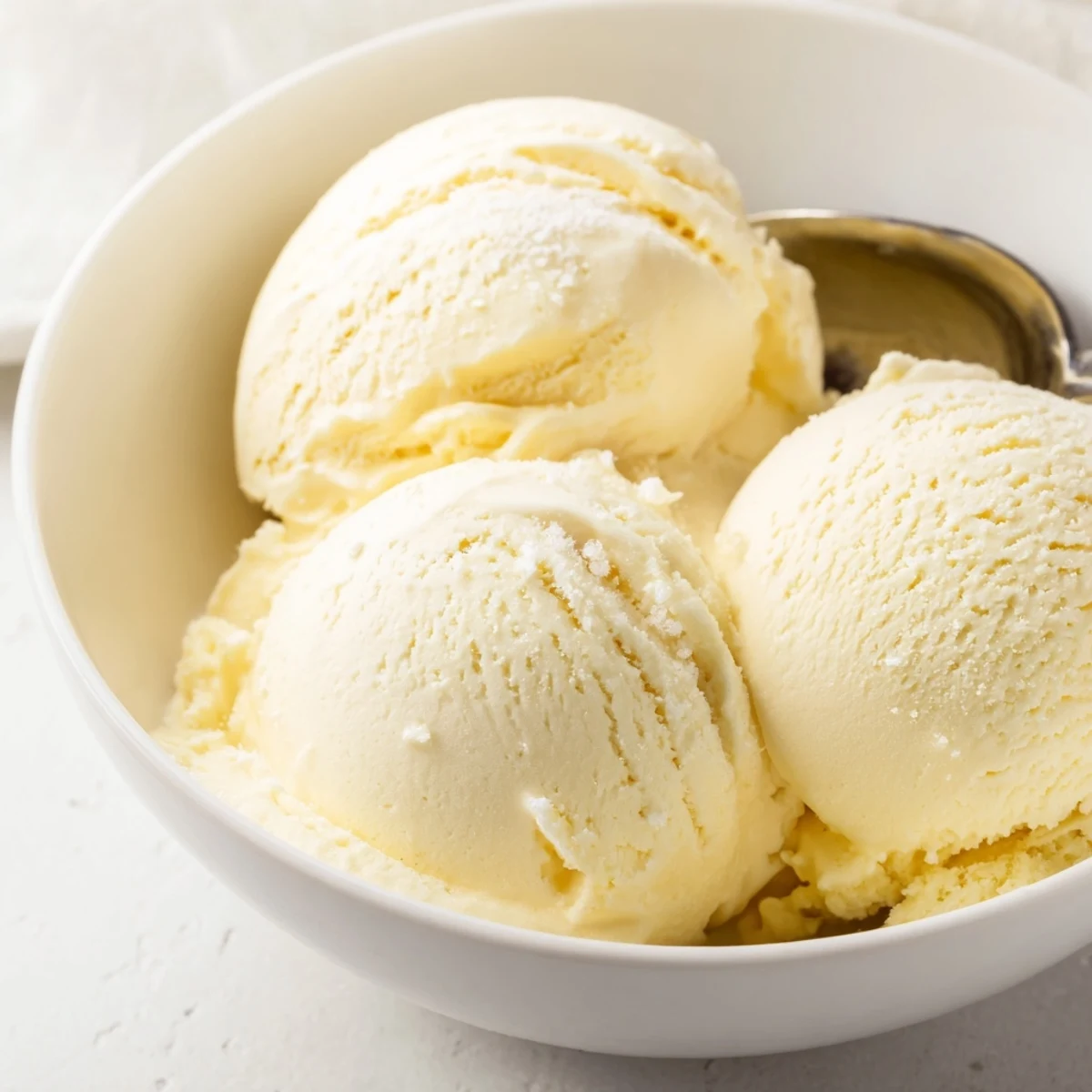 Smooth frozen custard-style vanilla ice cream garnished with chocolate shavings and mint leaf