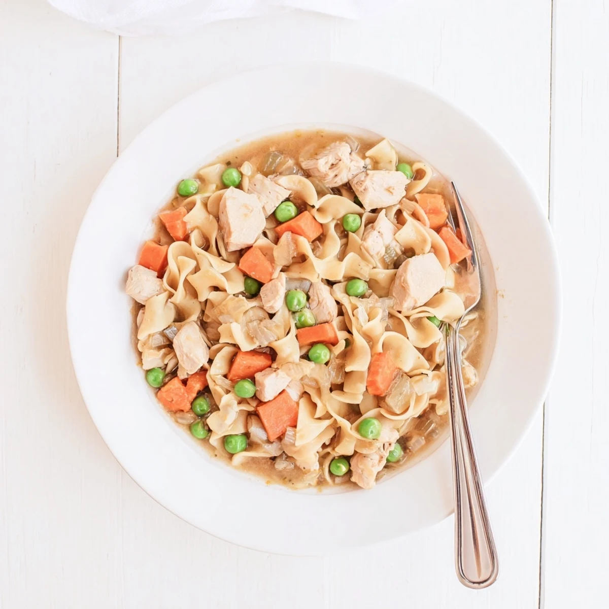 Hearty one pot chicken and noodles featuring succulent chicken pieces and wide egg noodles in a savory, comforting stew