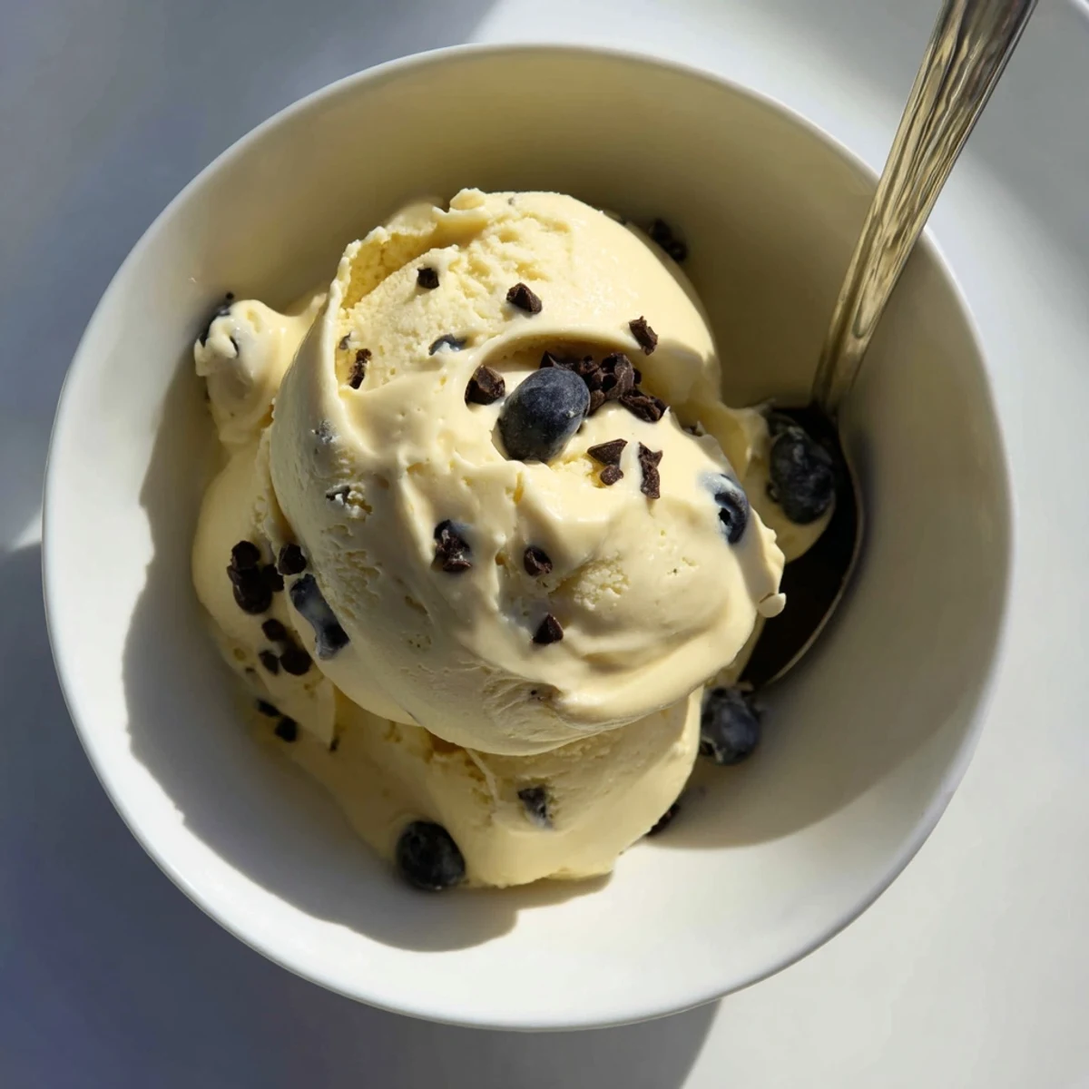 Homemade banana nice cream topped with chocolate chips and granola for a healthy dessert