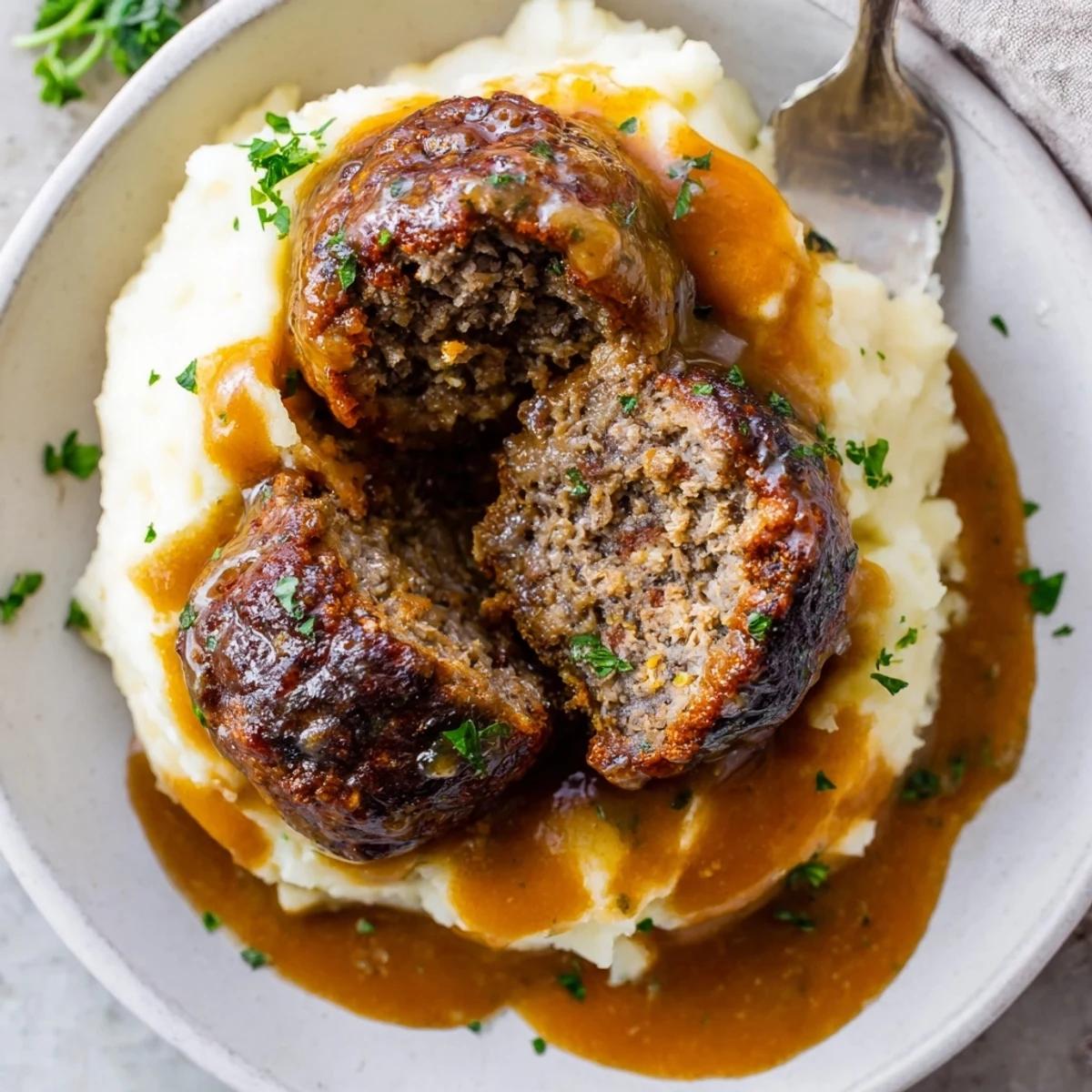 Crockpot Meatballs Gravy simmering in rich brown sauce over buttery mashed potatoes