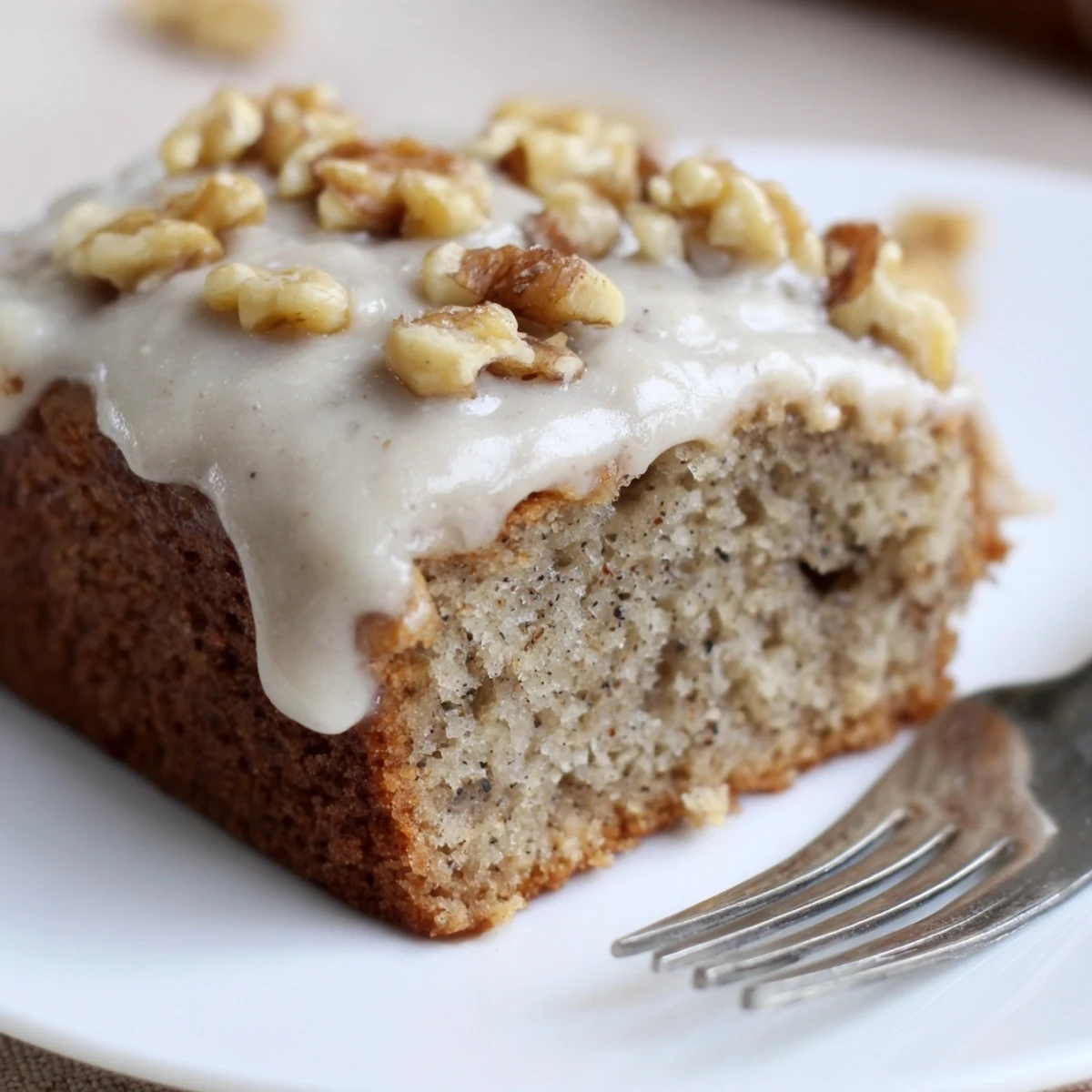 Warm Moist Banana Cake studded with chocolate chips, walnuts, sliced on plate.