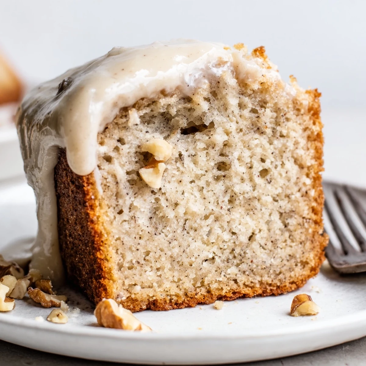 Slice of Moist Banana Cake served with steaming coffee and cream.