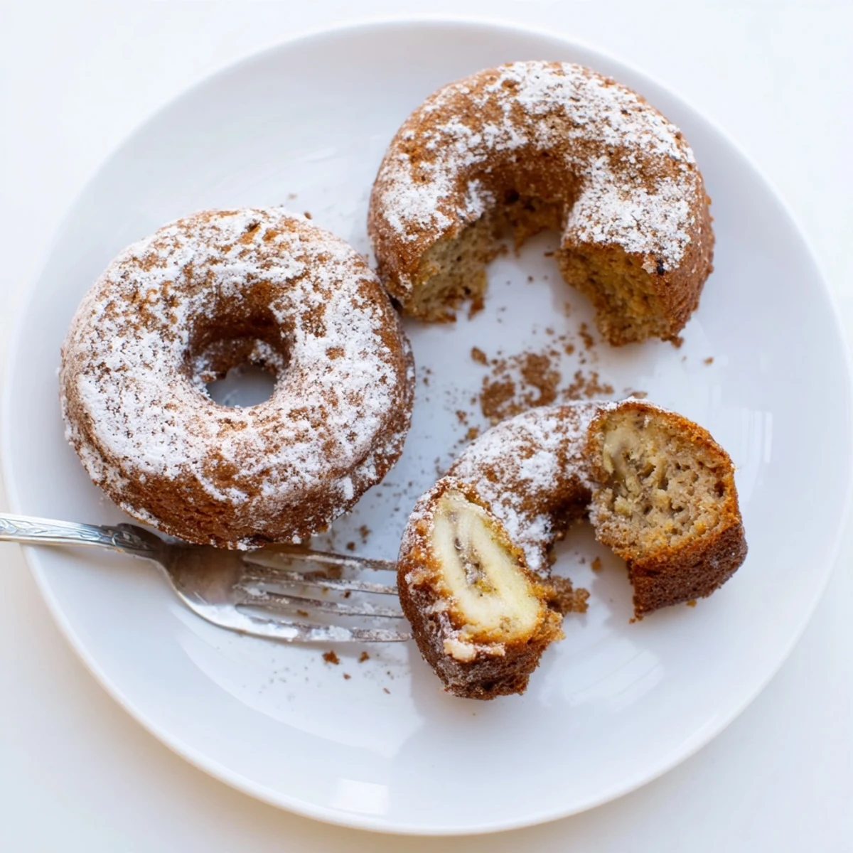 Banana Donuts cooling on a wire rack, golden edges and cinnamon dusting