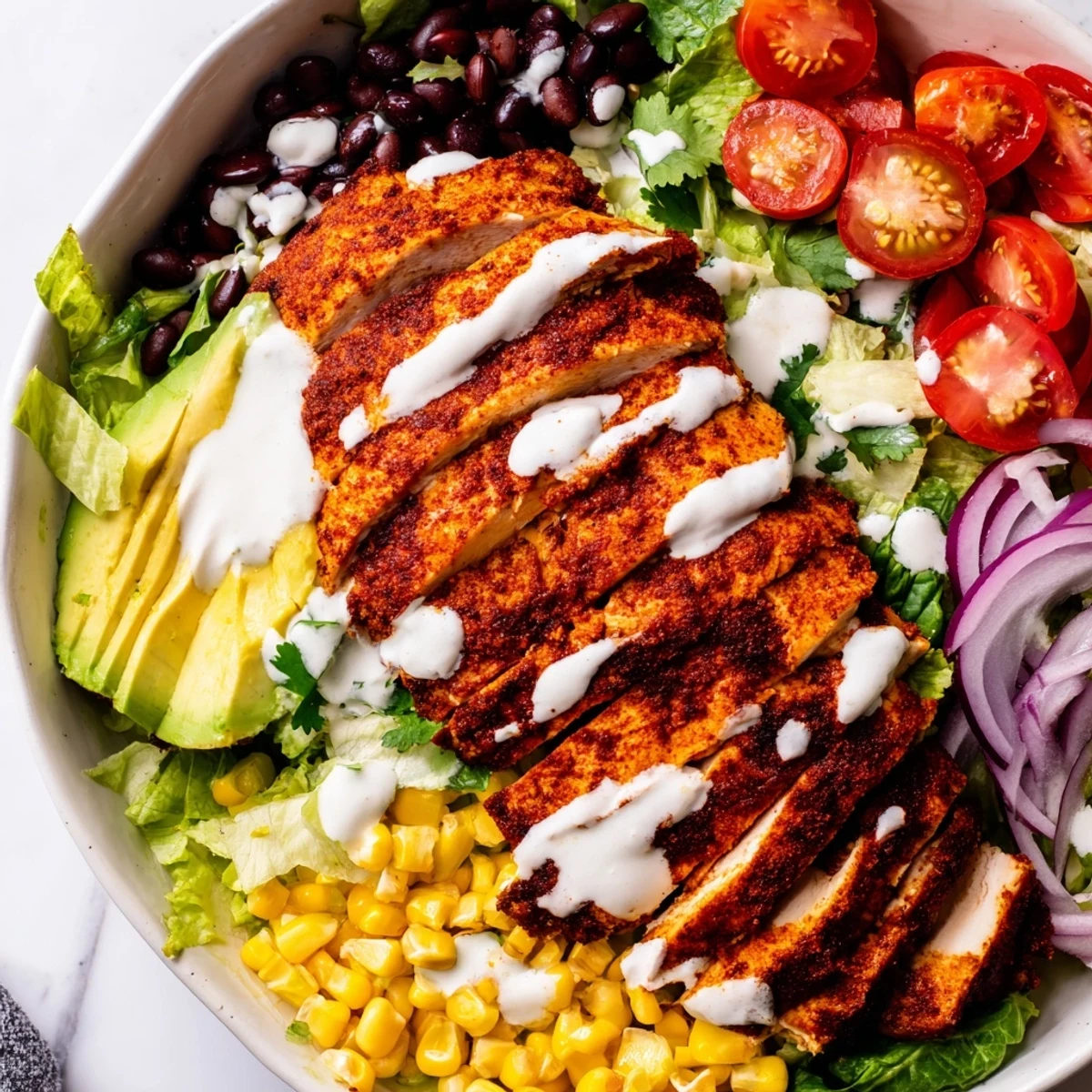 Vibrant Southwestern chicken salad bowl with grilled chicken, avocado, black beans, corn, and creamy lime dressing