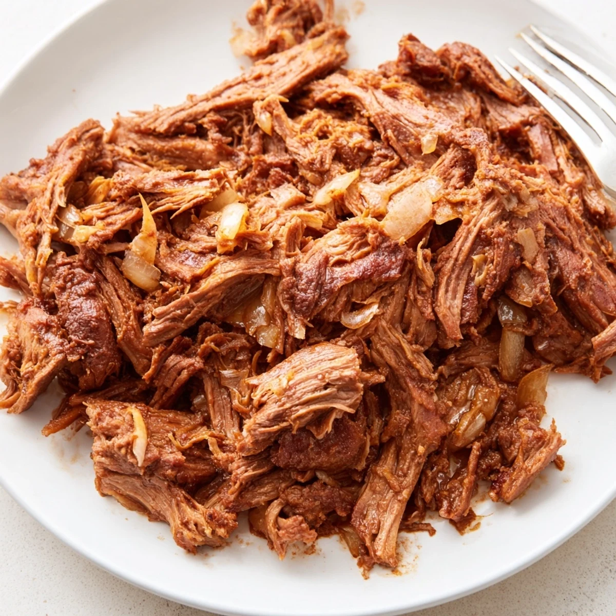 Glorious mounds of slow cooker beef barbacoa topped with fresh cilantro and diced white onion