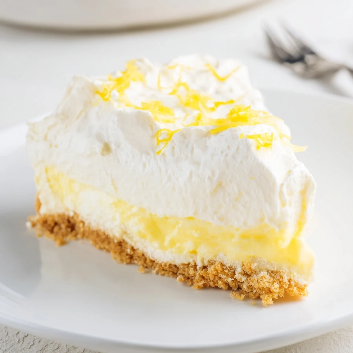 Sliced Lemon Lush Cake showing crisp cookie crust and zesty lemon aroma.