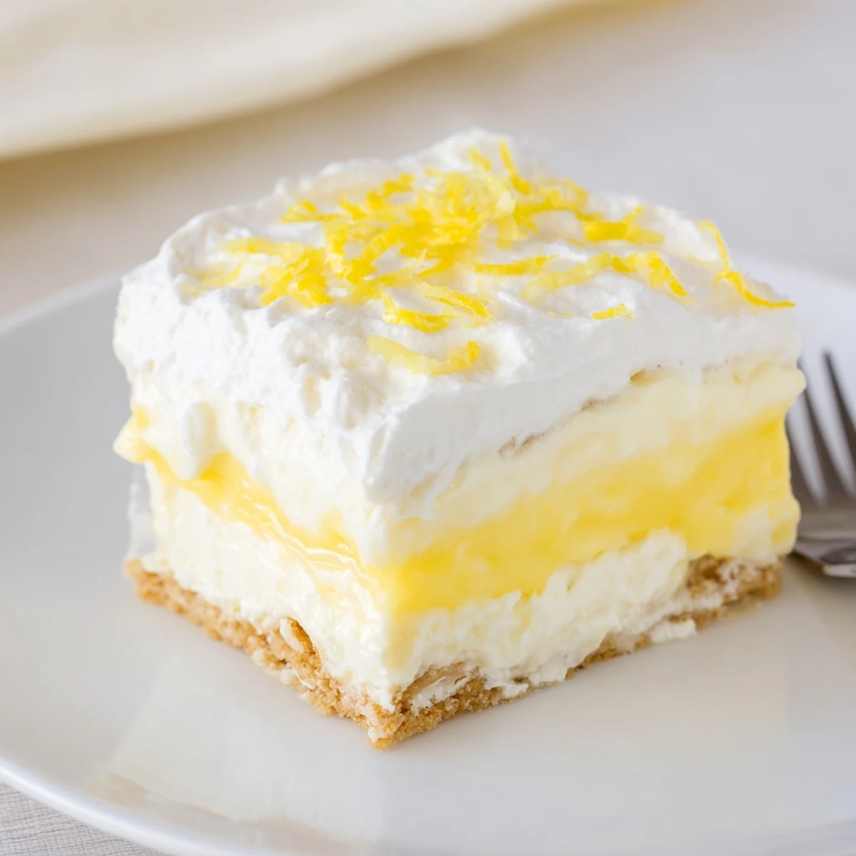 Lemon Lush Cake with creamy lemon layer and fluffy whipped topping, chilled.
