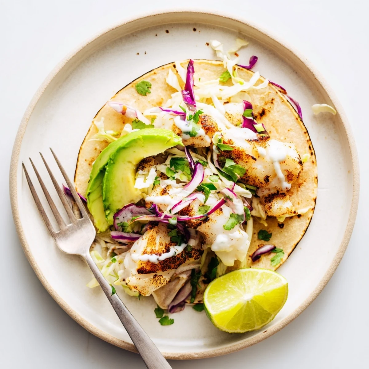 Sheet-pan dinner: Baked Cod Fish Tacos with Creamy Cilantro Lime Sauce, lime wedges.
