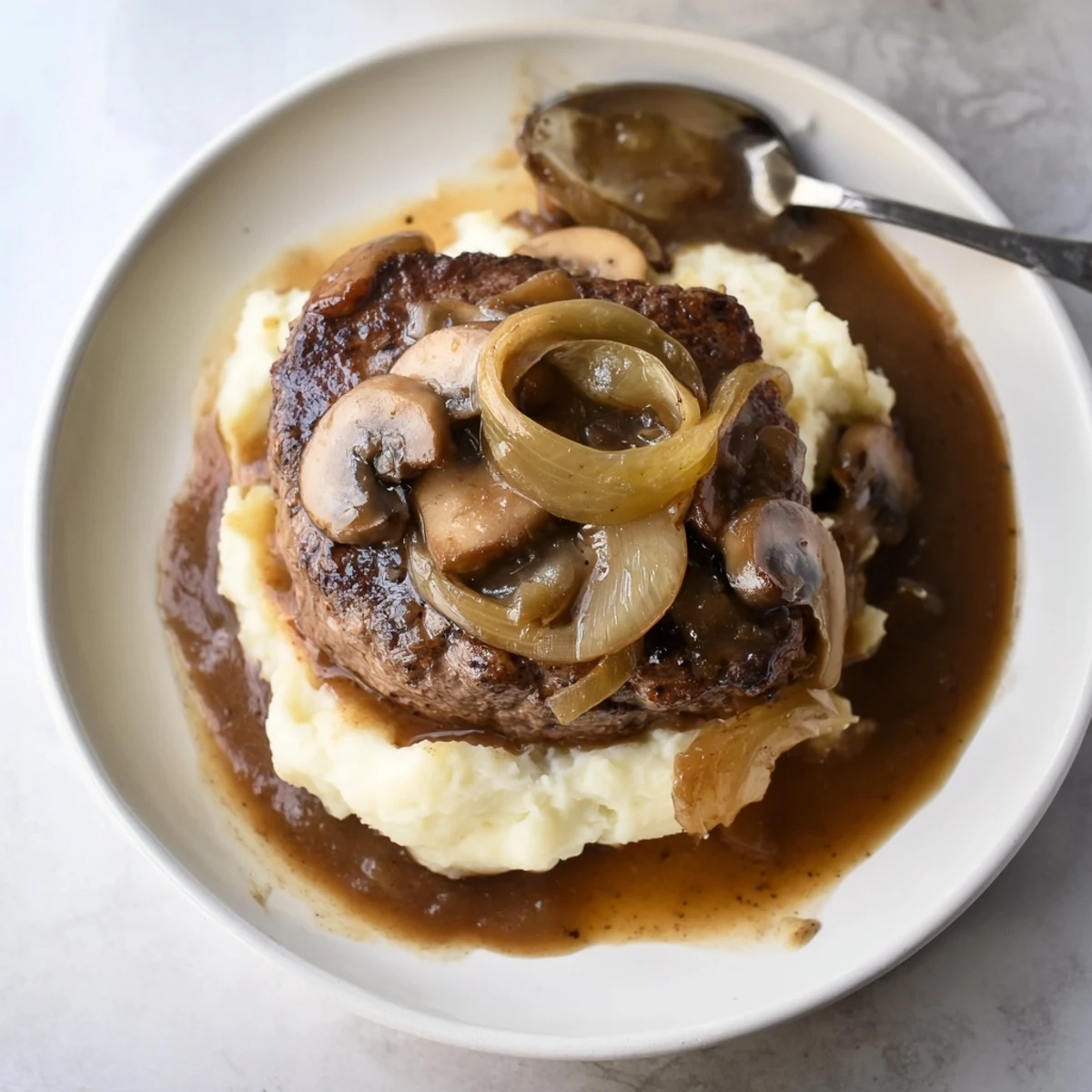 Hearty Country Style Smothered Cube Steak Recipe simmering in savory beef broth and onions