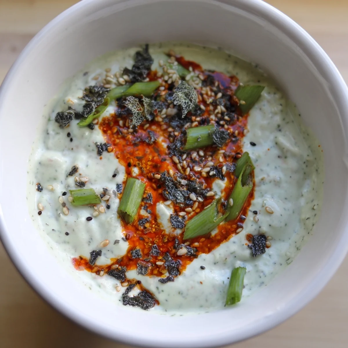 Bowl of charred scallion and chili crisp dip garnished with fresh scallions
