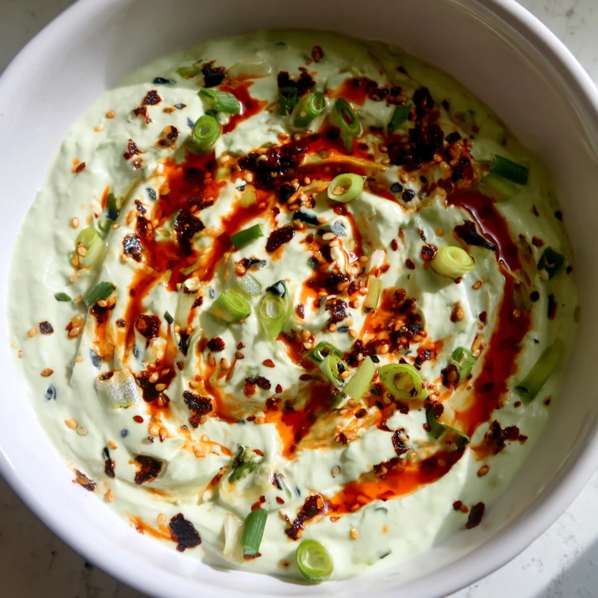Smoky charred scallion and chili crisp dip served alongside crisp vegetables