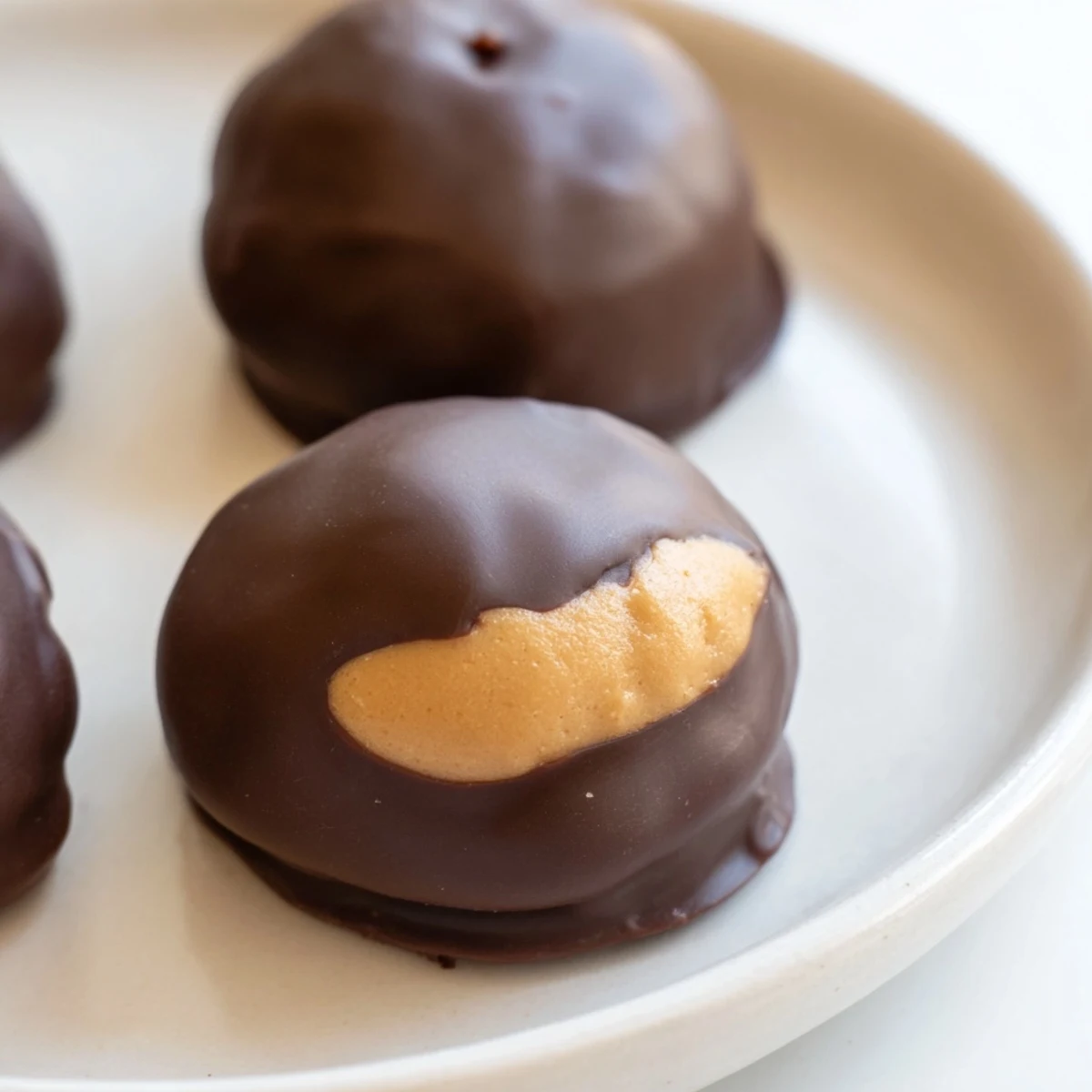 Buckeye Cookies with creamy peanut butter centers partially dipped in glossy chocolate