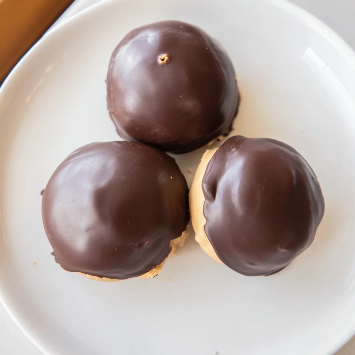 Chocolate-dipped Buckeye Cookies arranged on a parchment-lined tray for holiday cookie exchanges