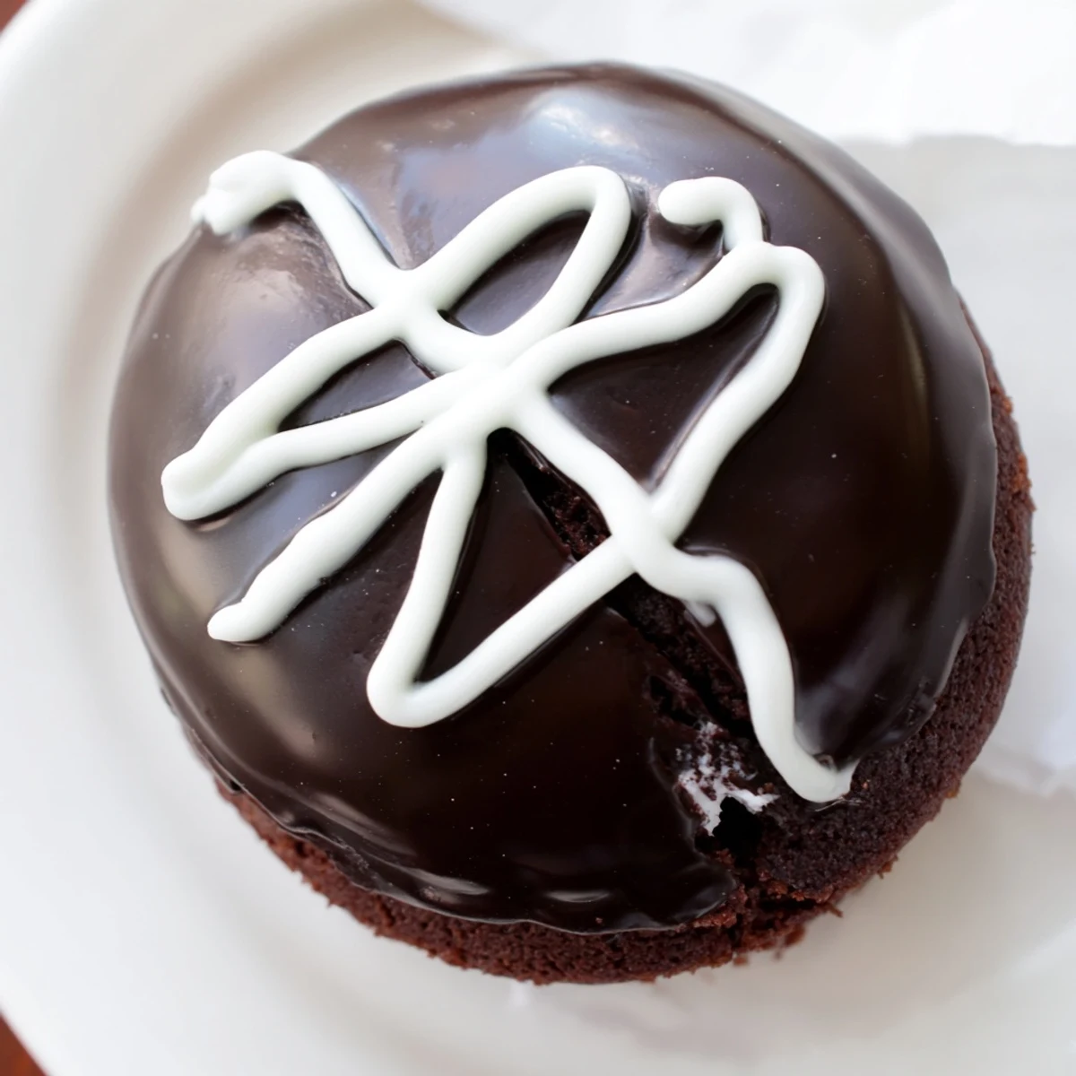 Homemade Hostess Cupcakes with glossy ganache, pillowy marshmallow centers, and iconic white swirls on a rustic baking sheet.