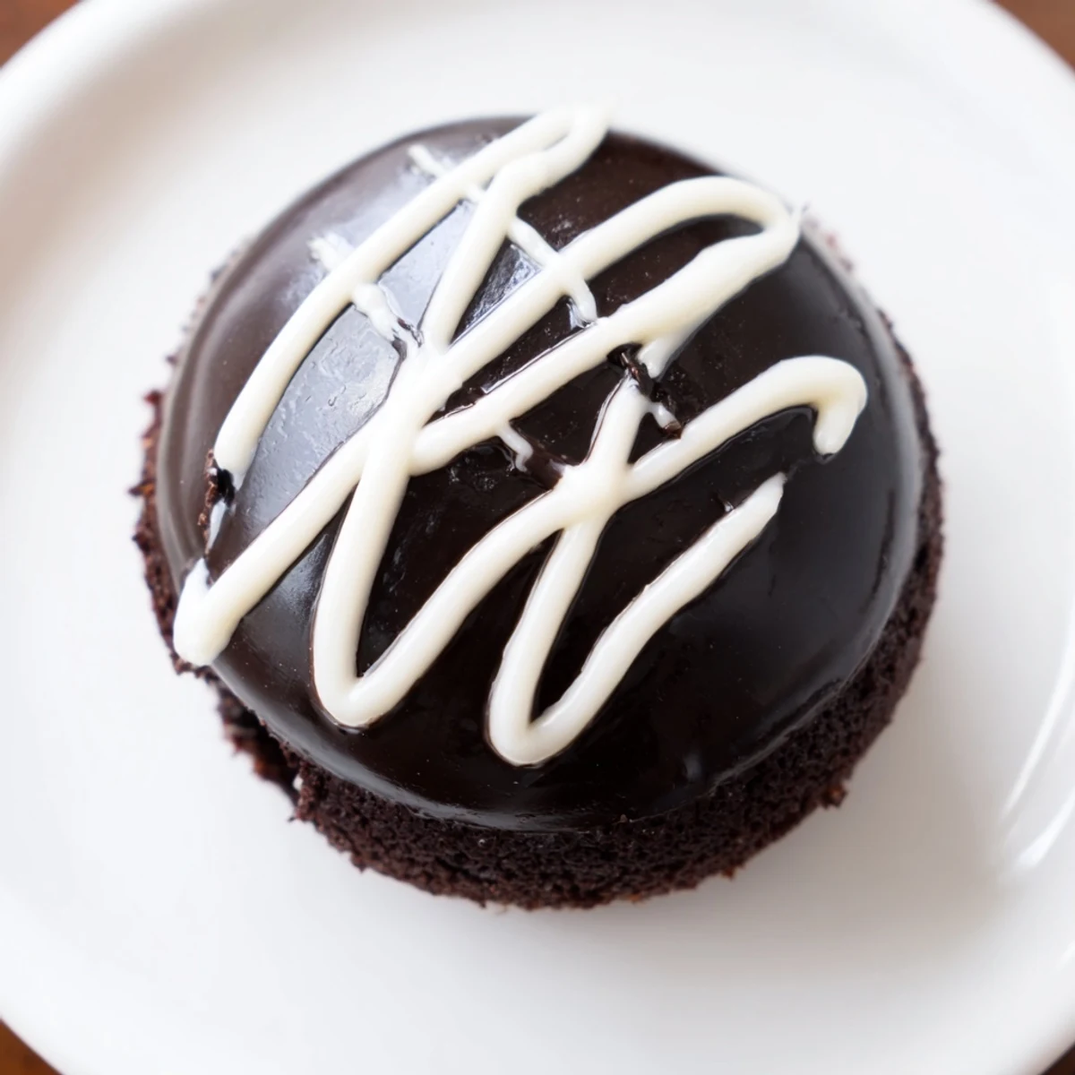 Rich Homemade Hostess Cupcakes dripping with shiny chocolate ganache and piped with fluffy marshmallow filling, topped with signature squiggles.