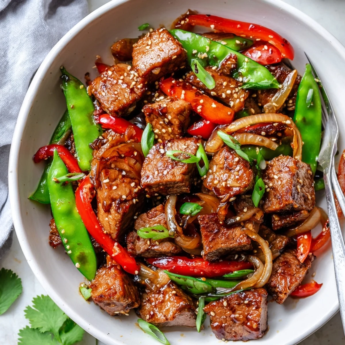 Tender Asian Inspired Cube Steak glazed in soy ginger sauce beside crisp stir-fried vegetables