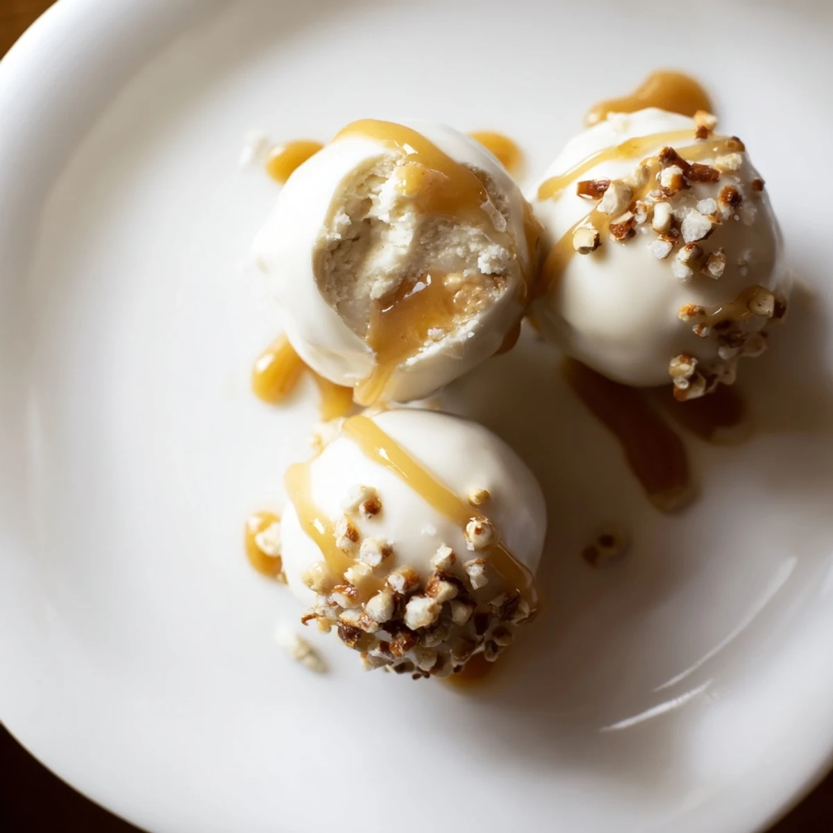 Bite sized salted caramel pretzel cheesecake balls garnished with crushed pretzels and flaky sea salt