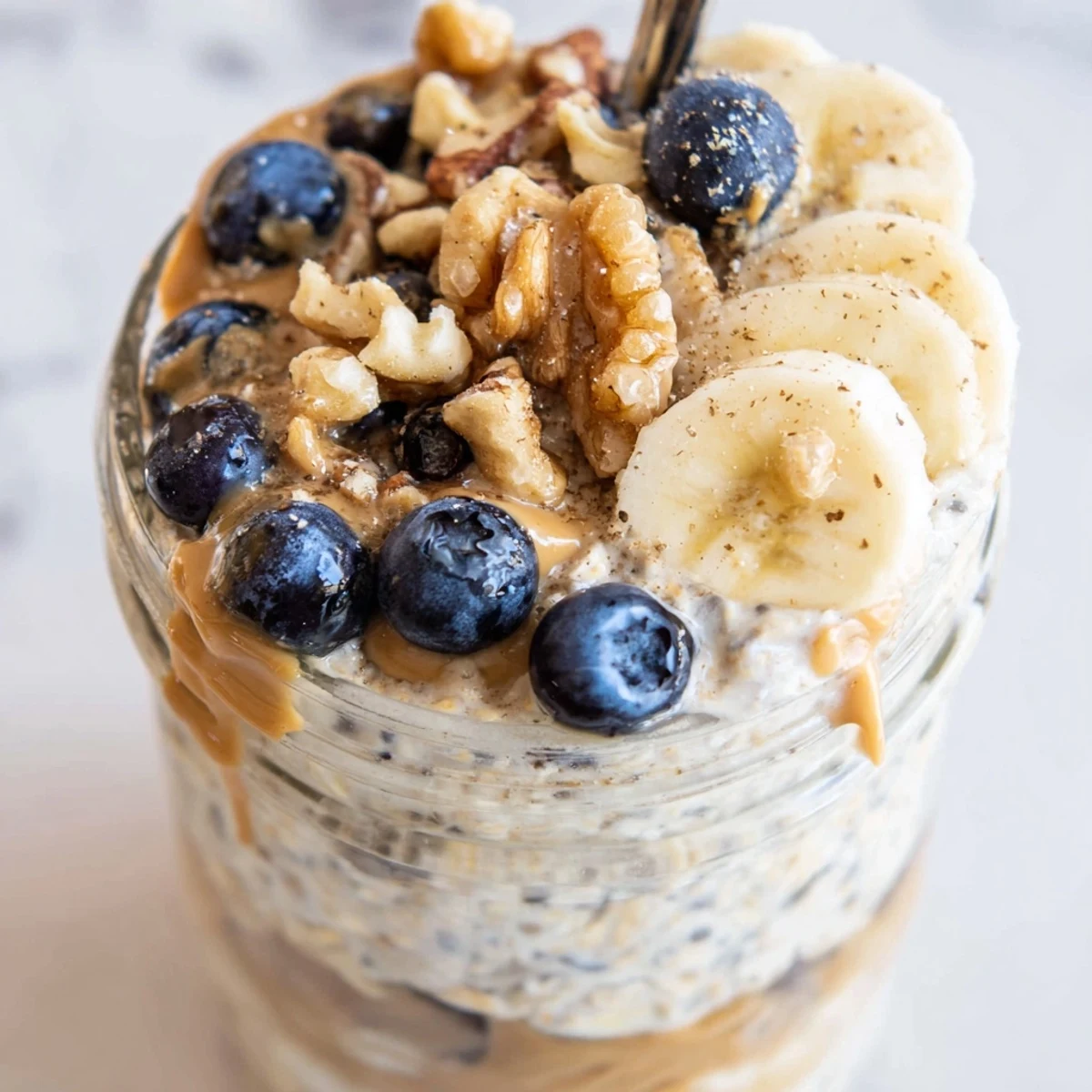 Creamy protein overnight oats topped with fresh berries and a nut butter drizzle