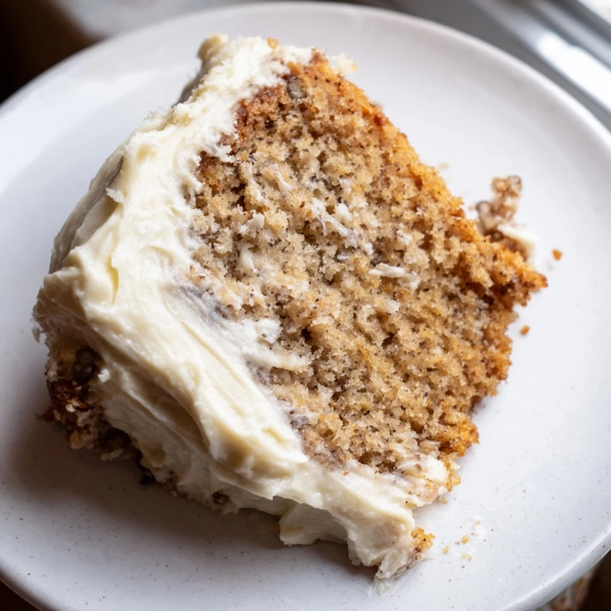Warm brown butter banana cake topped with swirls of fluffy cream cheese frosting ready to serve