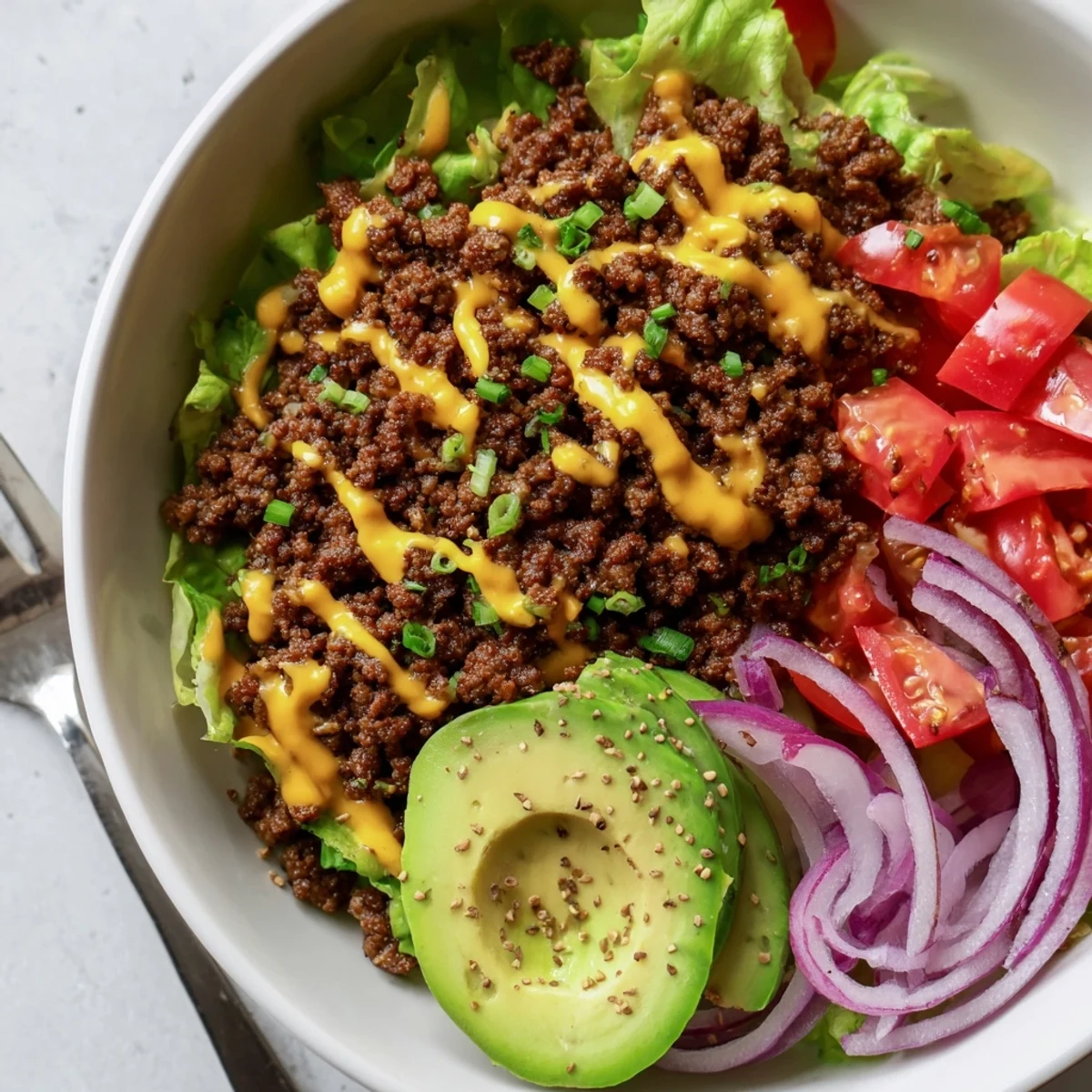 Colorful burger bowls loaded with seasoned beef, melted cheddar, and crisp vegetables