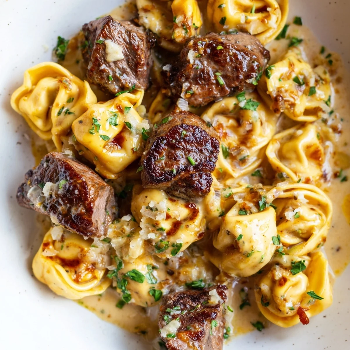 Garlic Steak Tortellini in creamy Parmesan sauce with fresh parsley and seared sirloin bites