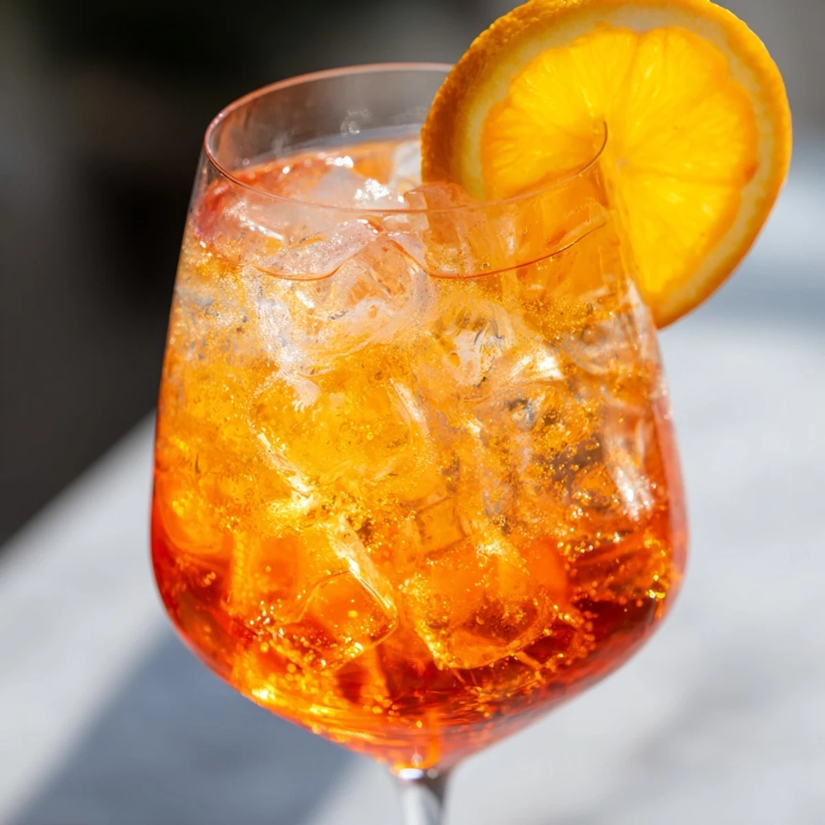 Golden Spritz served in a wine glass with ice and a fresh orange slice.  