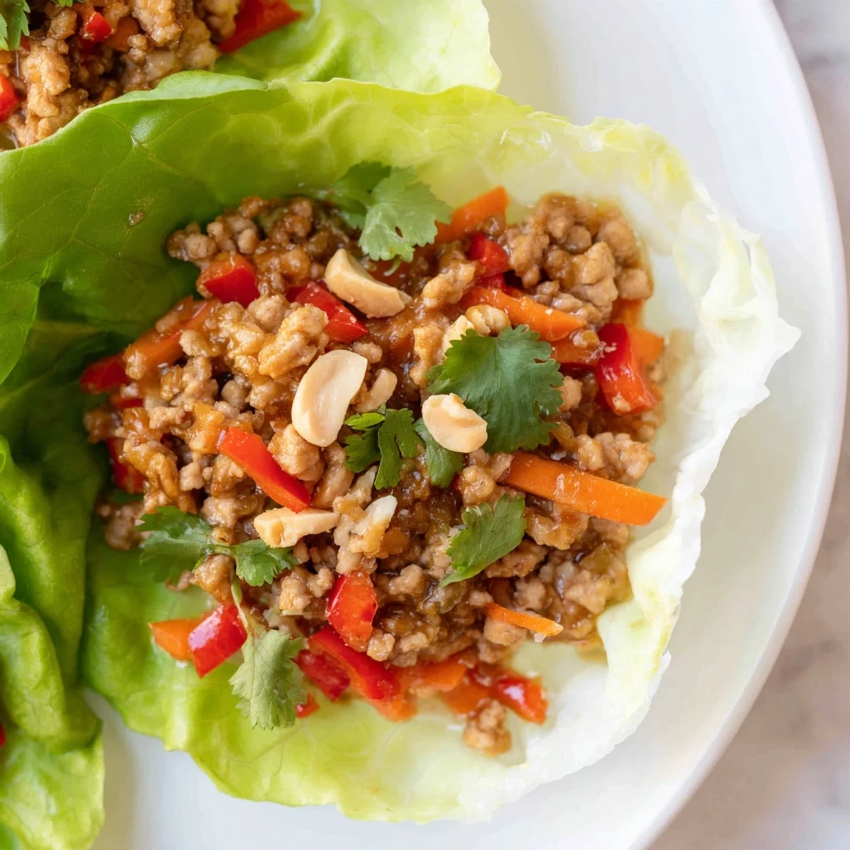 Healthy Thai chicken lettuce wraps featuring aromatic herbs and crunchy fresh toppings.