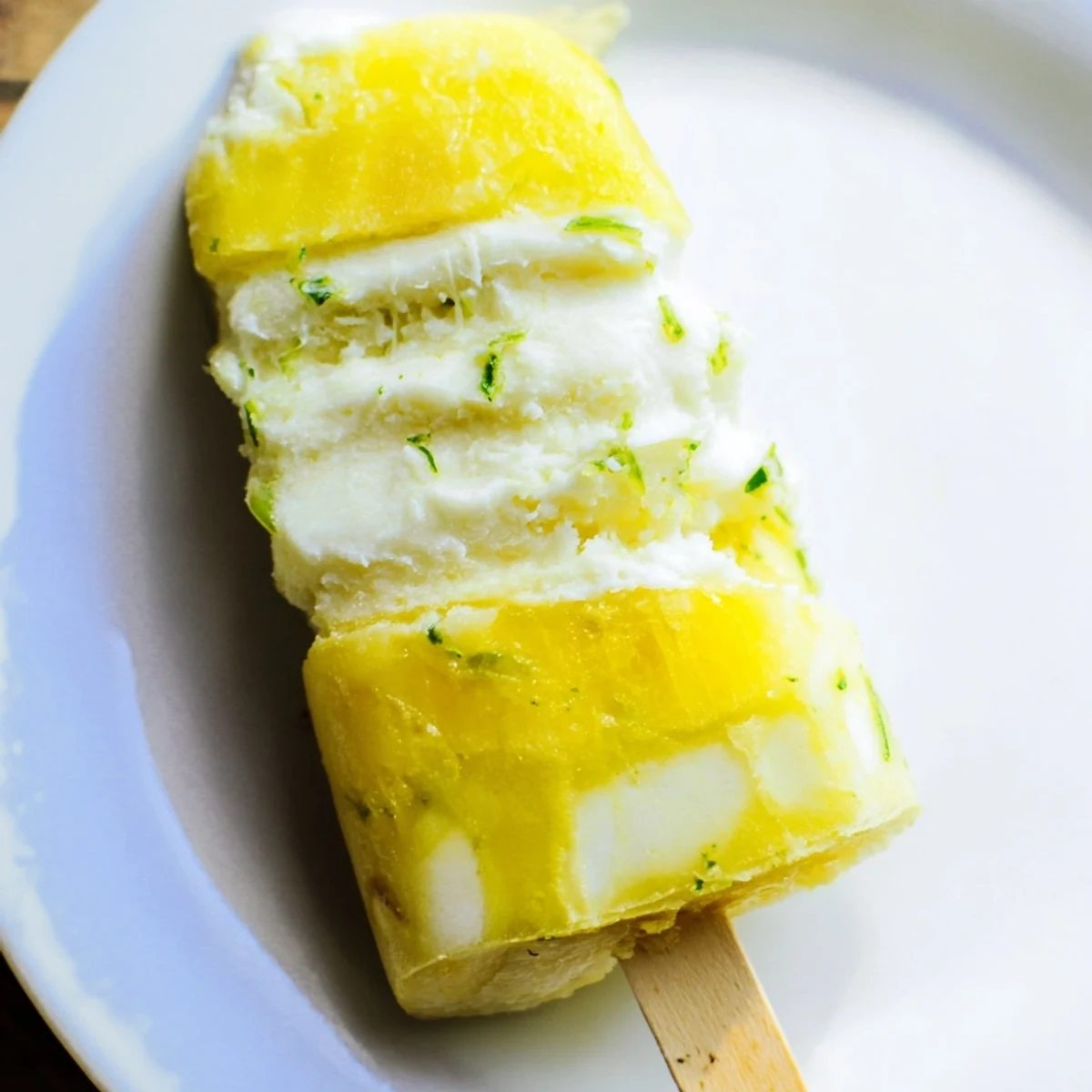 Frozen pineapple coconut lime treat garnished with shredded coconut and lime zest