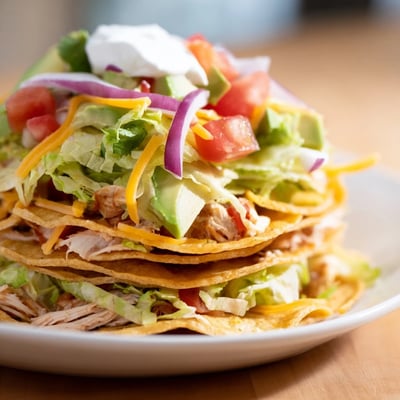 Seasoned shredded chicken served on golden corn tortillas with cheese and avocado.  