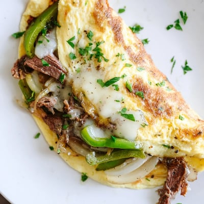 Fluffy folded omelette filled with tender beef, sautéed onions, and gooey provolone for breakfast  